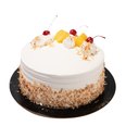 Pina colada cake with white frosting, toasted coconut sides, pineapple chunks, whipped cream, and cherries on top.